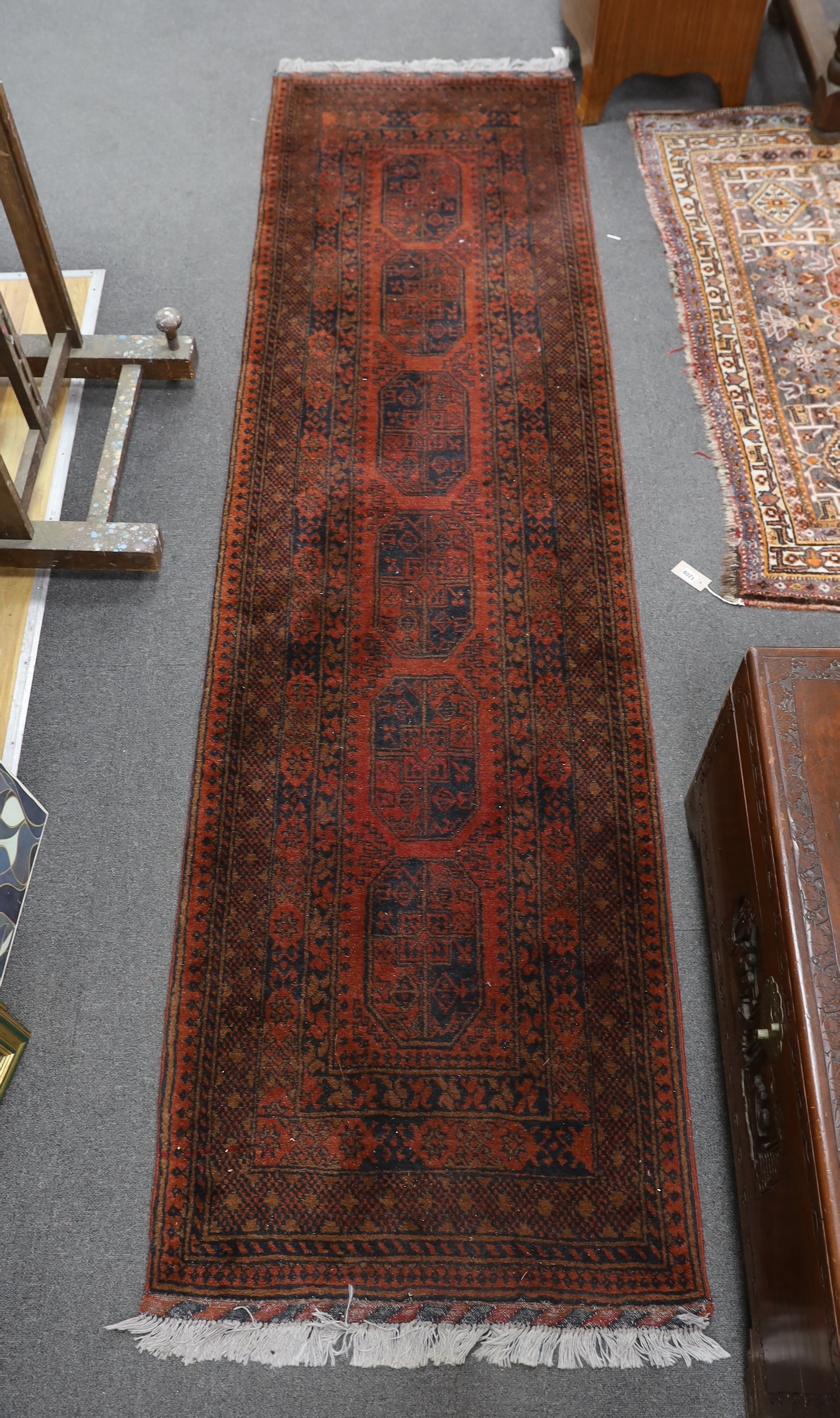 An Afghan red ground runner, 290 x 79cm